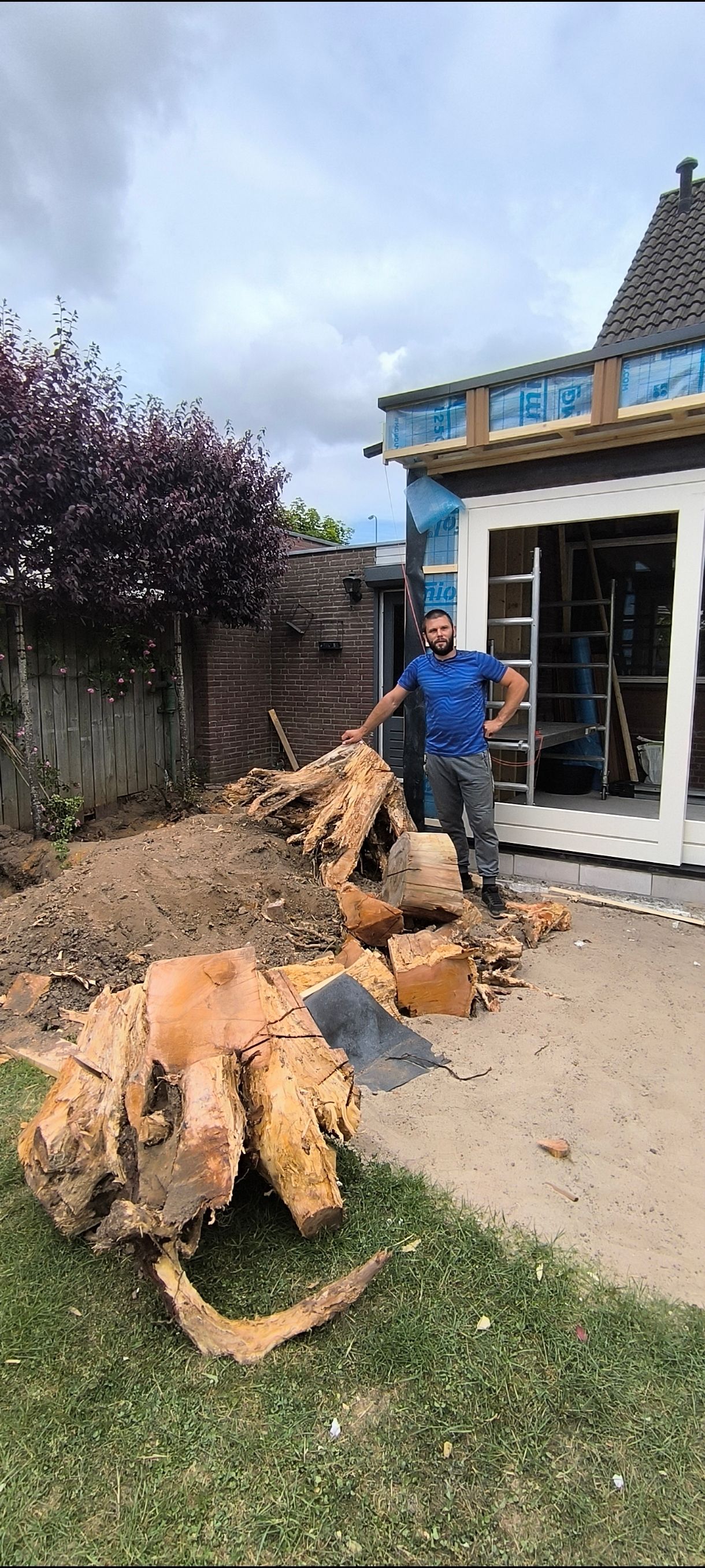 Denys naast een gerooide stronk met wortelkluit – Tuinwerk Denys
